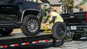 Man strapping a truck onto the Steel Deck Car Hauler