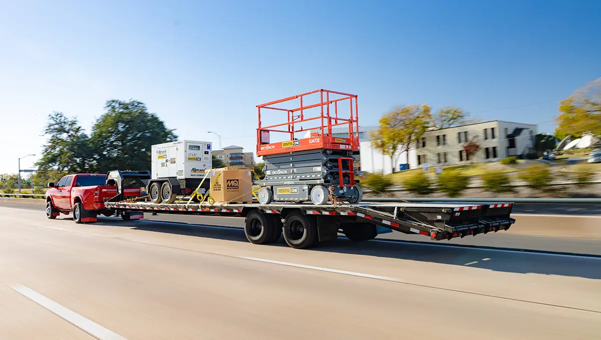Truck driving with a fully loaded Low-Pro Flatdeck Trailer With Duals