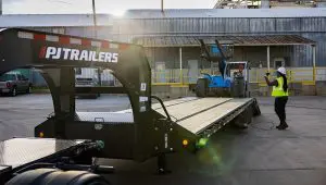 Trabajadores cargando una carretilla elevadora en el Low-Pro con remolque hidráulico Dove