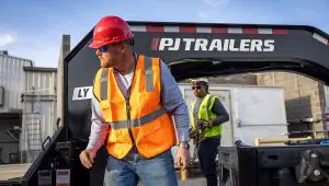 Trabajadores cargando equipo en el Low-Pro con remolque hidráulico Dove