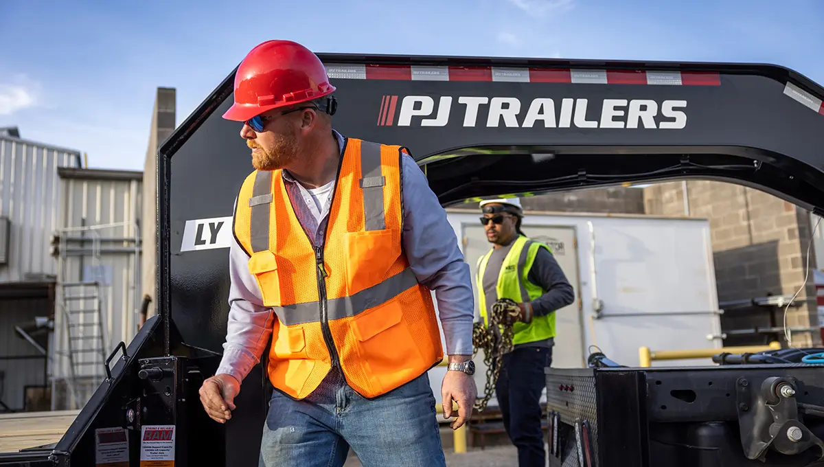 Trabajadores cargando equipo en el Low-Pro con remolque hidráulico Dove