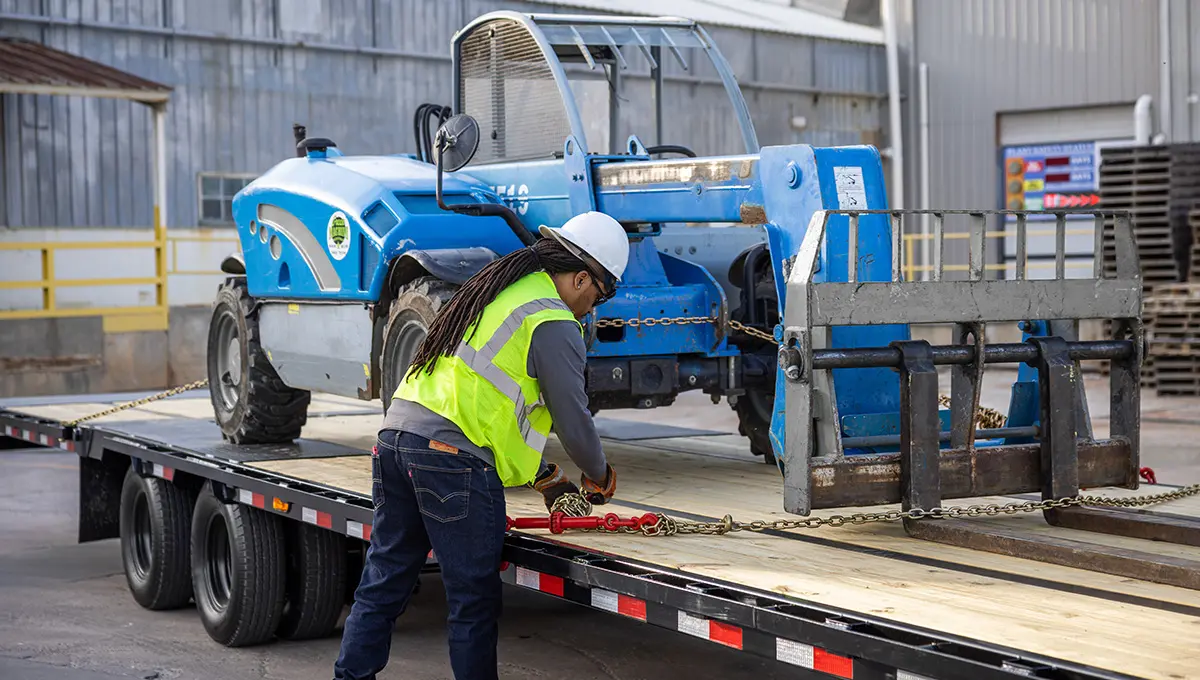 Trabajador sujetando una carretilla elevadora al Low-Pro con remolque hidráulico Dove