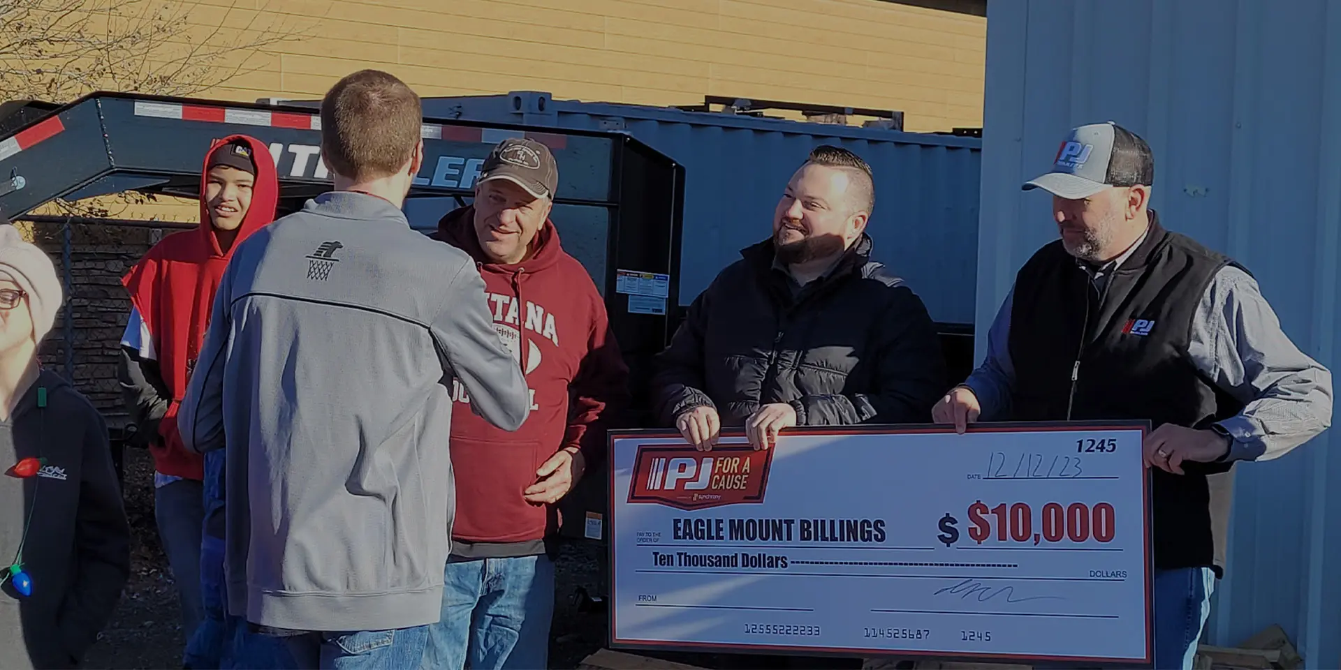 PJ Trailers employees present a $10,000 donation to Eagle Mount Billings
