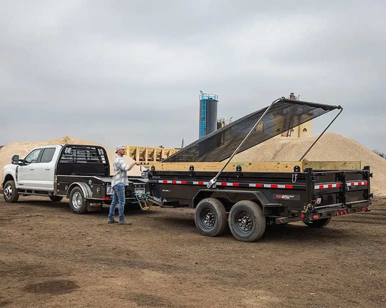 Worker lowering the swing arm to secure cargo on the Voyager dump trailer