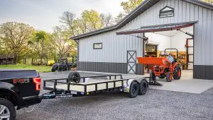 Worker driving a Kubota front loader onto the 83